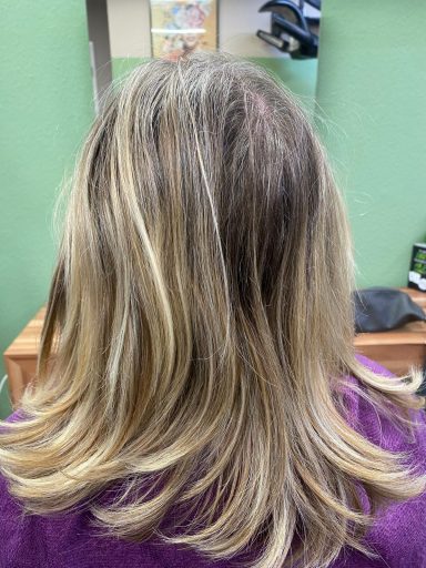 Langes, leicht gewelltes Haar in verschiedenen Brauntönen mit blonden Highlights.