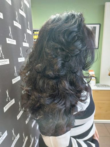 Dunkel, lockiges Haar, seitlich betrachtet, in einem eleganten Styling.